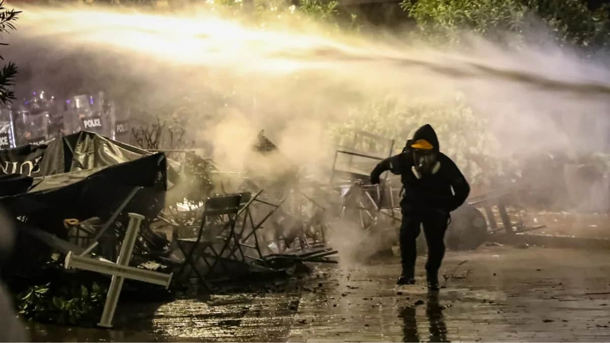 Участник оппозиционного митинга во время столкновений с полицией, Тбилиси, Грузия, 4 октября 2025 года. Фото: David Mdzinarishvili / EPA