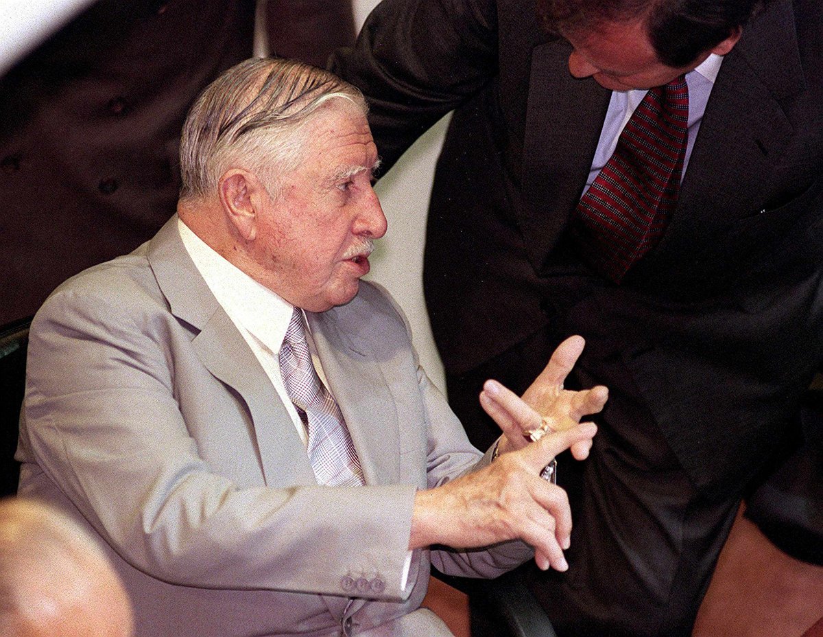 Чилийский генерал Аугусто Пиночет беседует с коллегой по Конгрессу в Вальпараисо, Чили, 17 марта 1998 года. Фото: EPA