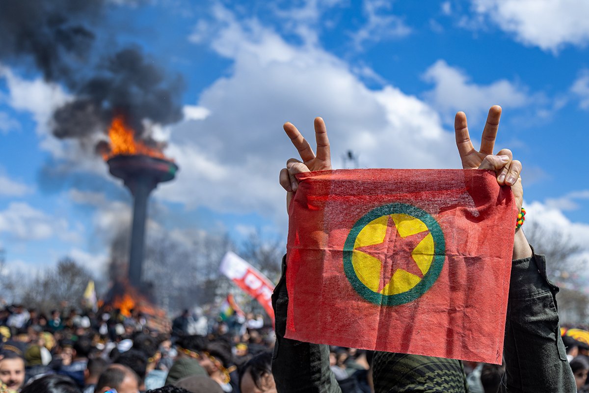 Сторонники Партии равенства и демократии народов (DEM) держат флаг Рабочей партии Курдистана (РПК) и выкрикивают лозунги во время митинга в честь празднования Новруза в Диярбакыре, Турция, 21 марта 2025 года. Фото: Metin Yoksu / EPA-EFE