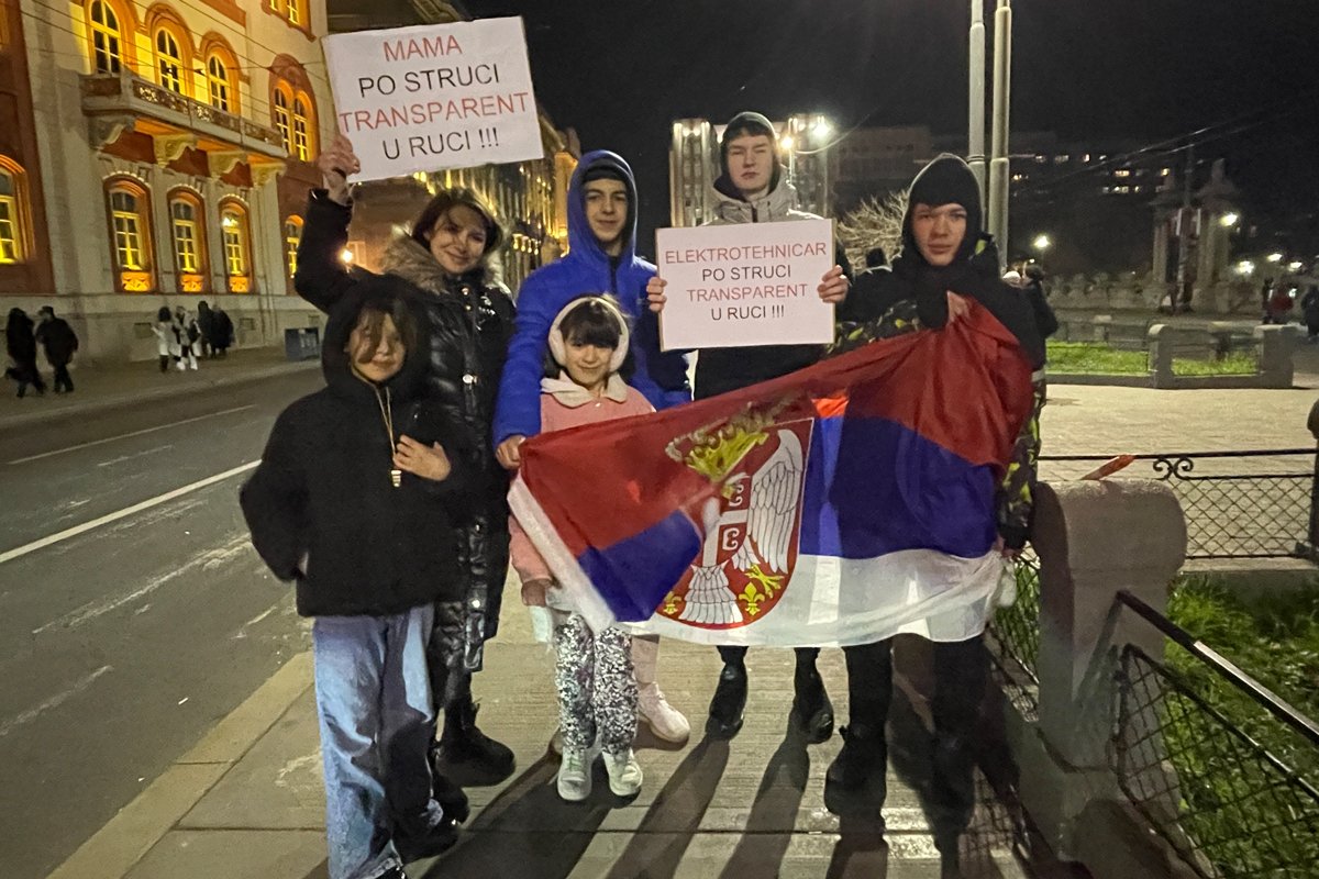 Семья с плакатом. Фото: Илья Азар / «Новая газета Европа»