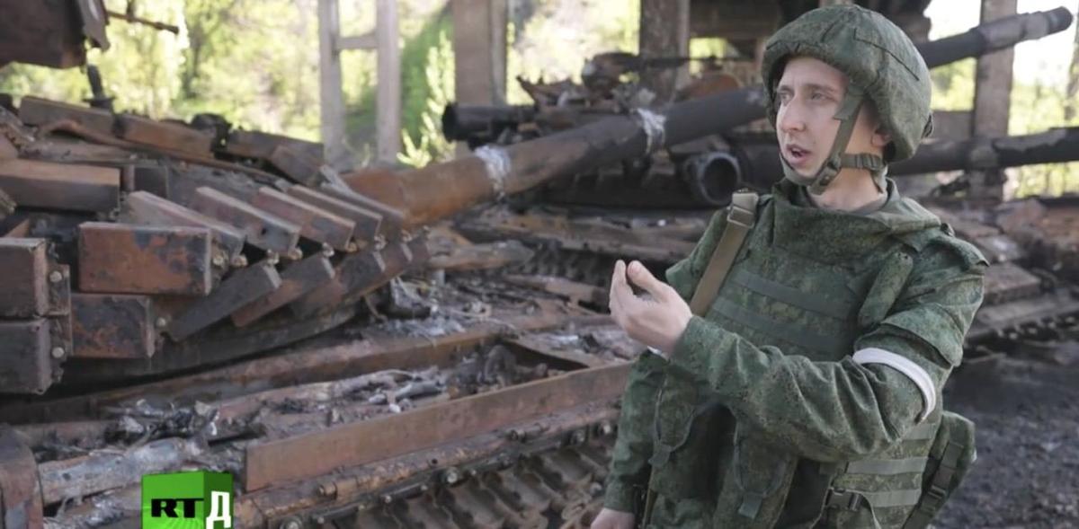 Виктор Петенко, музыкант Донецкой филармонии. В каске и бронежилете, которые выглядят новыми. Фото: скрин видео